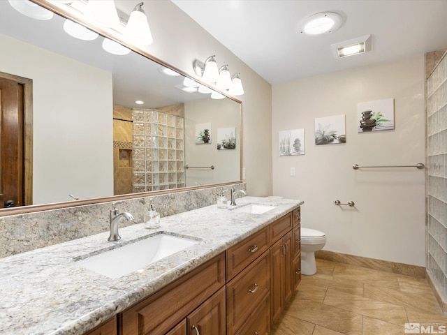 full bathroom with double vanity, tile patterned floors, tiled shower, and a sink