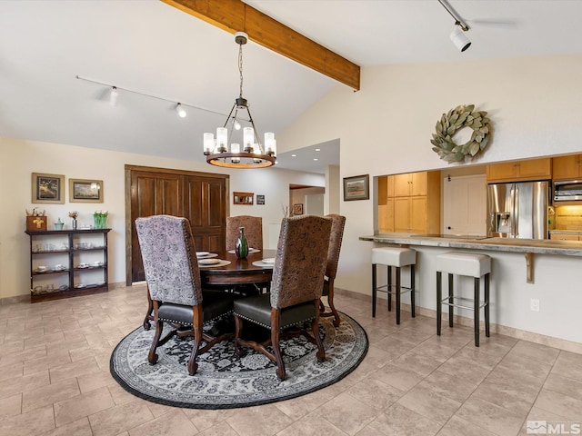 dining room with vaulted ceiling with beams, rail lighting, baseboards, and a notable chandelier