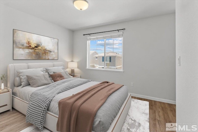 bedroom featuring baseboards and wood finished floors