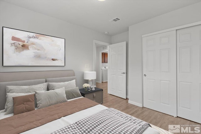 bedroom featuring visible vents, baseboards, a closet, and light wood-type flooring