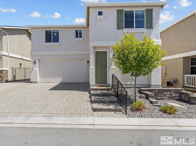 traditional-style house with decorative driveway, a garage, and stucco siding