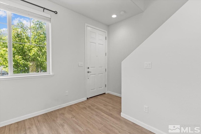 empty room featuring recessed lighting, baseboards, and wood finished floors
