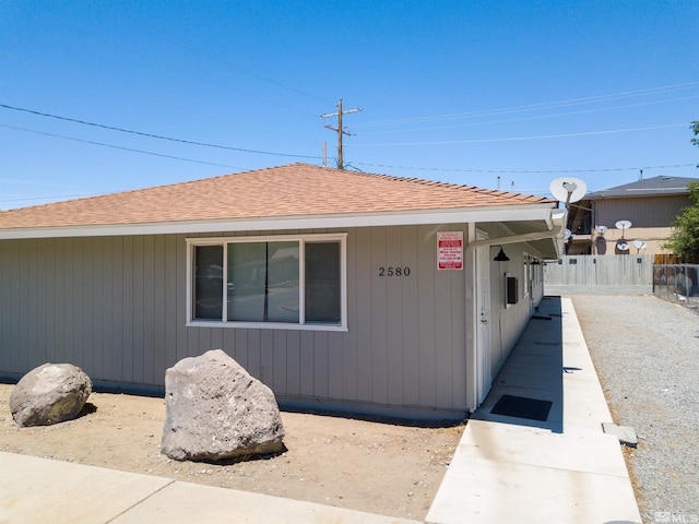 view of front of home featuring a shingled roof and fence