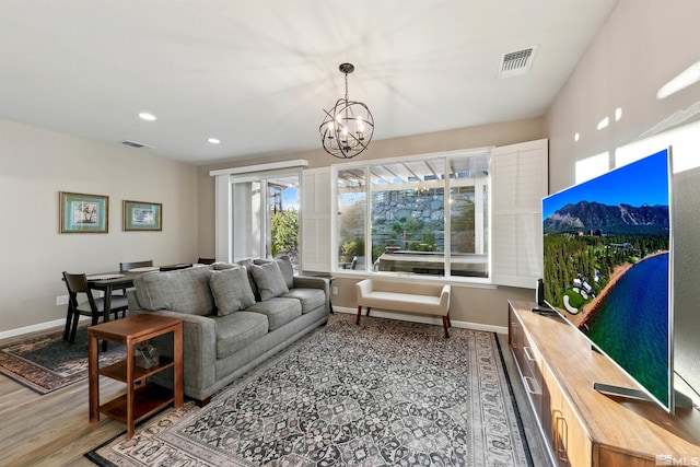 living room featuring visible vents, wood finished floors, baseboards, a notable chandelier, and recessed lighting