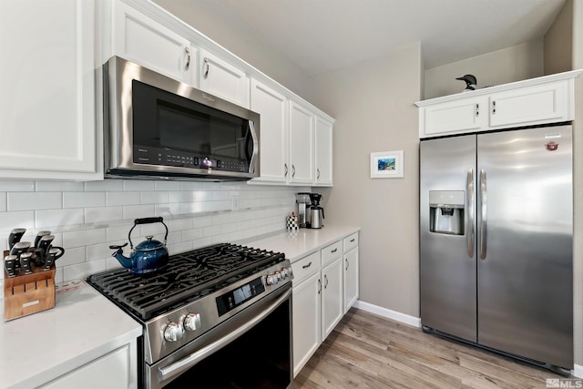 kitchen featuring white cabinetry, appliances with stainless steel finishes, and light wood-style flooring