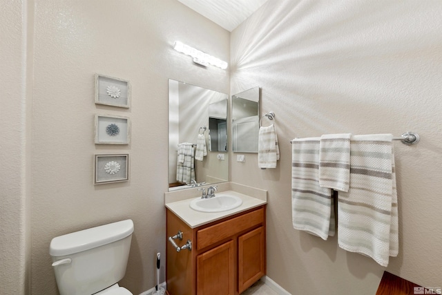 half bathroom with vanity and toilet