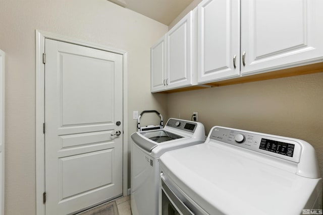 laundry room featuring cabinet space, light tile patterned floors, and washing machine and clothes dryer