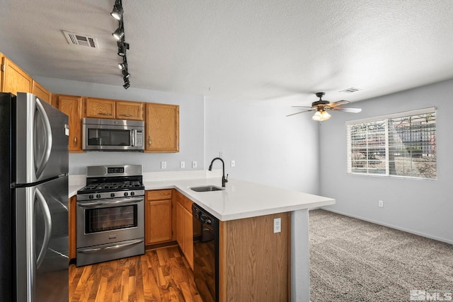 kitchen featuring a sink, light countertops, stainless steel appliances, a peninsula, and visible vents