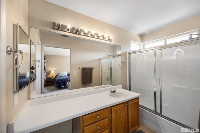 ensuite bathroom with connected bathroom, shower / bath combination with glass door, visible vents, and vanity