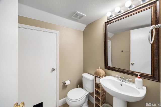 half bathroom featuring visible vents, a sink, and toilet