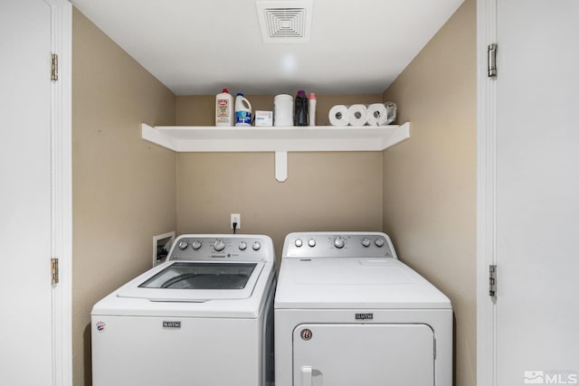 washroom featuring washer and dryer, laundry area, and visible vents
