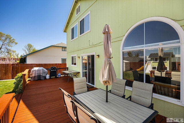 deck with area for grilling, fence, and outdoor dining space