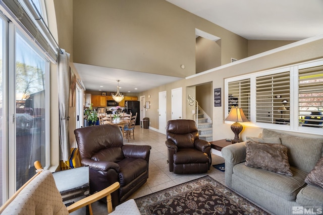 living area with stairs, high vaulted ceiling, baseboards, and light tile patterned floors