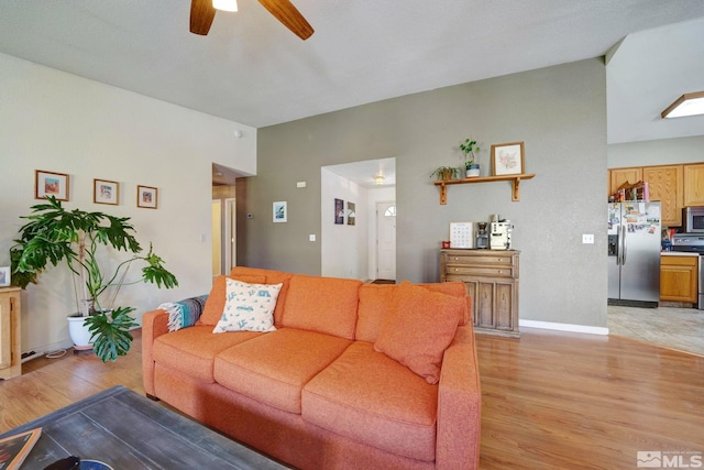living room with a ceiling fan and light wood-style flooring
