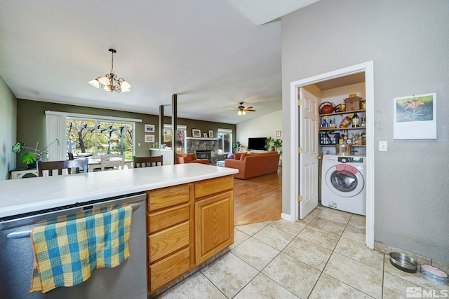 kitchen featuring washer / dryer, light countertops, light tile patterned floors, ceiling fan with notable chandelier, and dishwasher