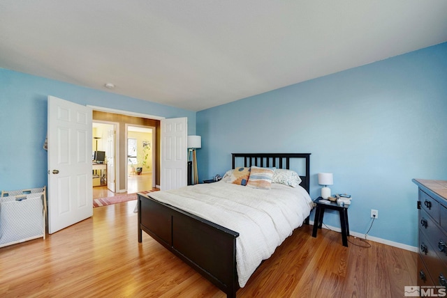 bedroom with light wood-style floors and baseboards
