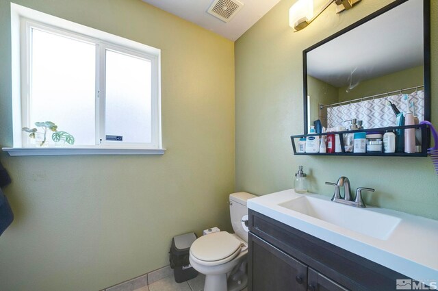 bathroom with toilet, visible vents, tile patterned flooring, and vanity
