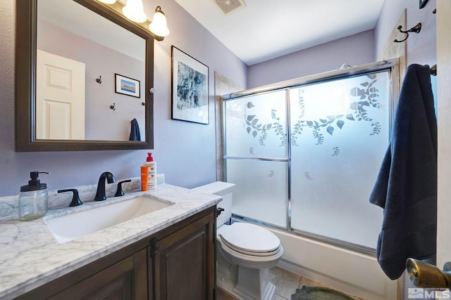 full bathroom featuring tile patterned flooring, vanity, toilet, combined bath / shower with glass door, and visible vents