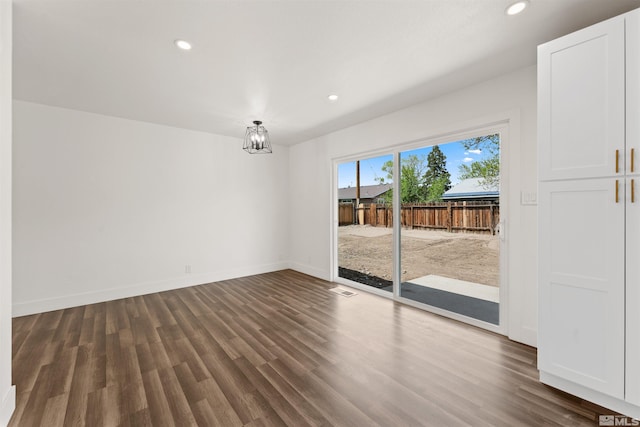 empty room with dark wood-type flooring, recessed lighting, and baseboards