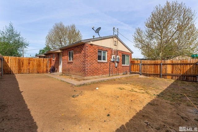 view of property exterior featuring brick siding and a fenced backyard