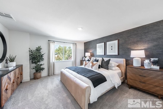 bedroom featuring baseboards, visible vents, and light carpet