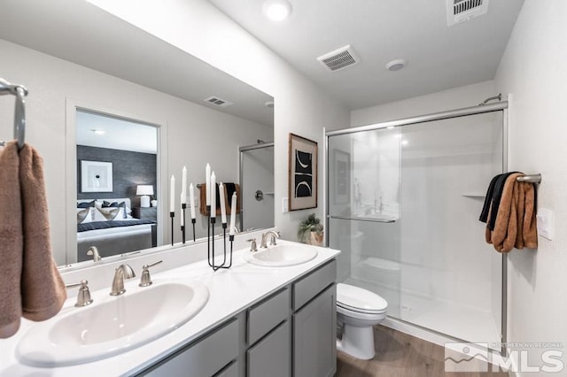 ensuite bathroom with a sink, a stall shower, and visible vents