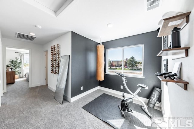 exercise room with baseboards, carpet, and visible vents