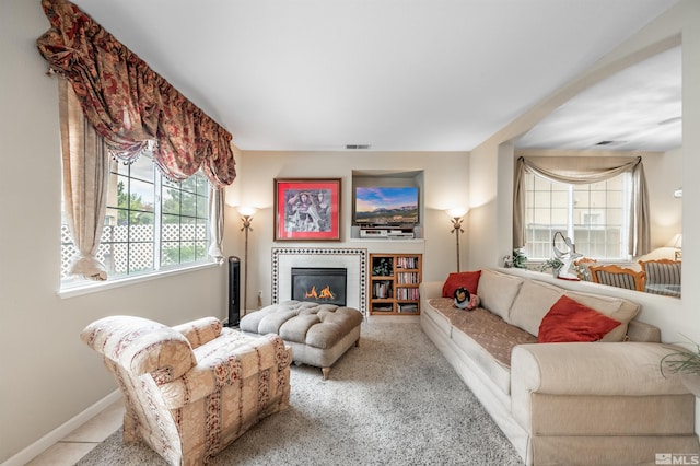 living area with carpet flooring, baseboards, visible vents, and a glass covered fireplace