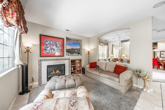 tiled living area with plenty of natural light, a fireplace, and visible vents