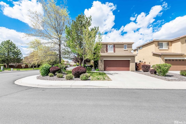 traditional home featuring an attached garage, driveway, and stucco siding