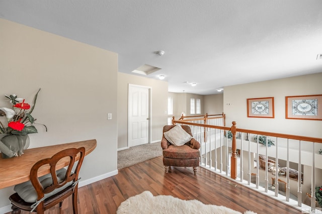 living area featuring baseboards, attic access, and wood finished floors