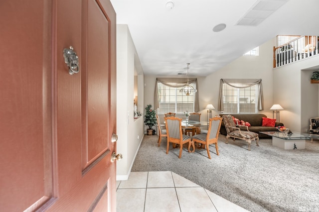dining area featuring an inviting chandelier, light tile patterned floors, and light carpet