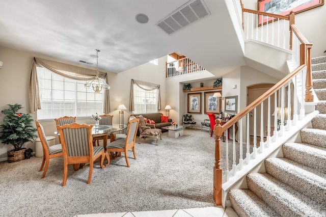 dining room with stairs, a chandelier, carpet flooring, and visible vents
