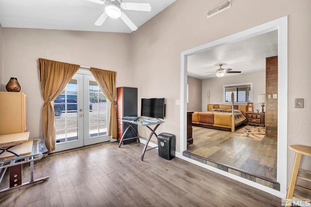 living area featuring french doors, a ceiling fan, wood finished floors, and visible vents
