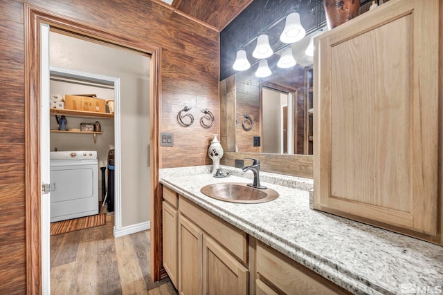 bathroom with vanity, baseboards, separate washer and dryer, and wood finished floors