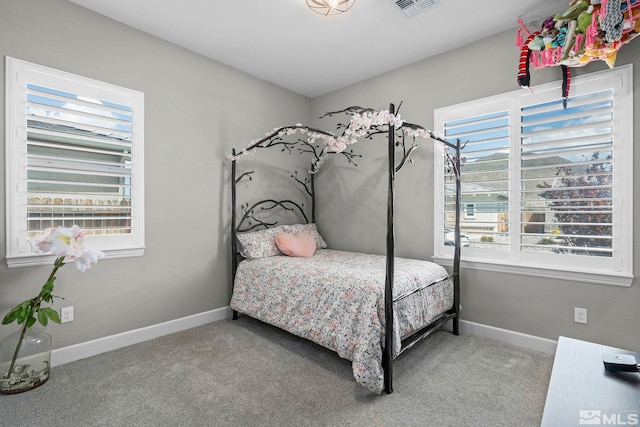 carpeted bedroom with baseboards, multiple windows, and visible vents