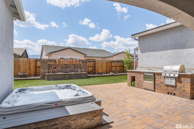 view of patio / terrace featuring a grill, fence, an outdoor kitchen, and an outdoor hot tub