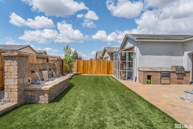view of yard with a fenced backyard, a sunroom, area for grilling, and a patio area
