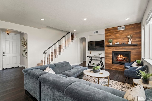 living room with arched walkways, baseboards, visible vents, and recessed lighting