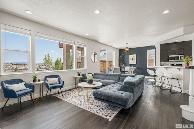 living room featuring baseboards, recessed lighting, a textured ceiling, and dark wood-type flooring