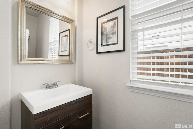 bathroom featuring vanity and a textured wall