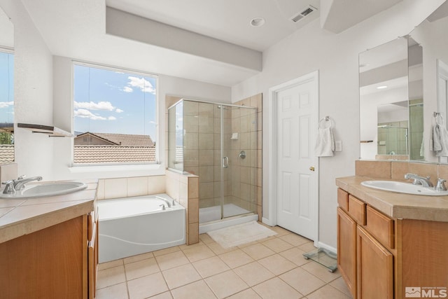 bathroom featuring visible vents, a sink, tile patterned floors, and a shower stall