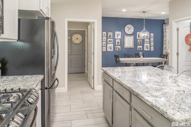 kitchen featuring recessed lighting, decorative light fixtures, appliances with stainless steel finishes, and light stone counters