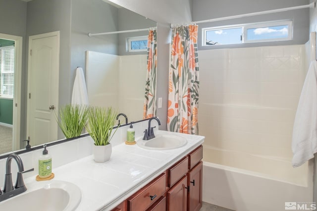 full bathroom featuring double vanity, shower / bath combination with curtain, and a sink