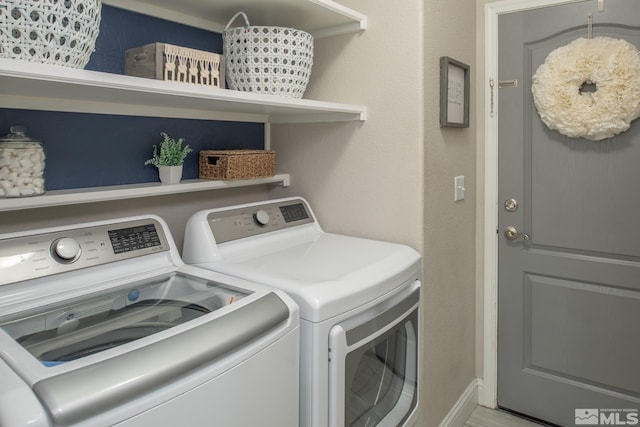 washroom with laundry area, washer and clothes dryer, and baseboards