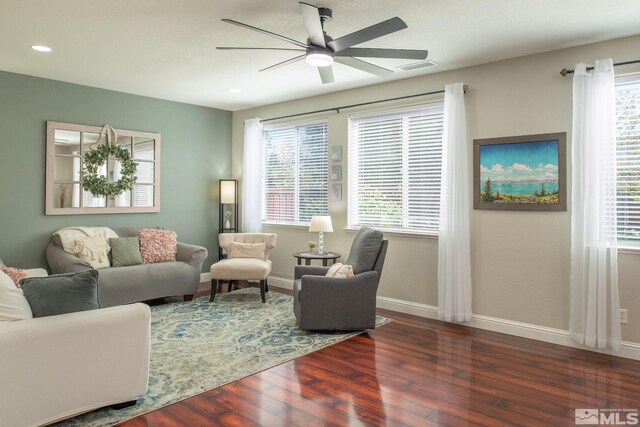 living room featuring baseboards, a ceiling fan, wood finished floors, and visible vents