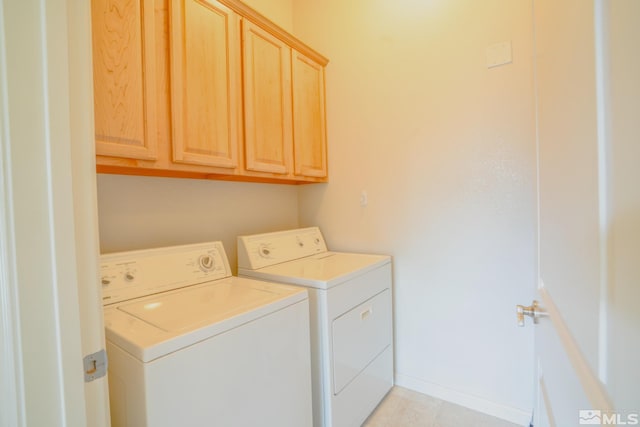 clothes washing area featuring light tile patterned floors, independent washer and dryer, and cabinet space