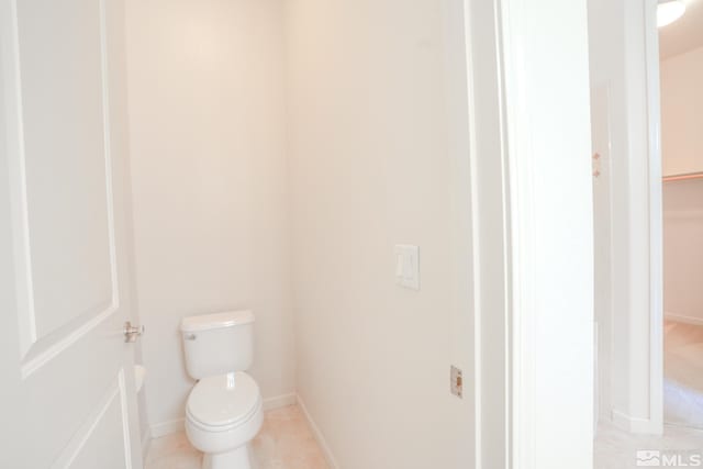 bathroom featuring baseboards and toilet