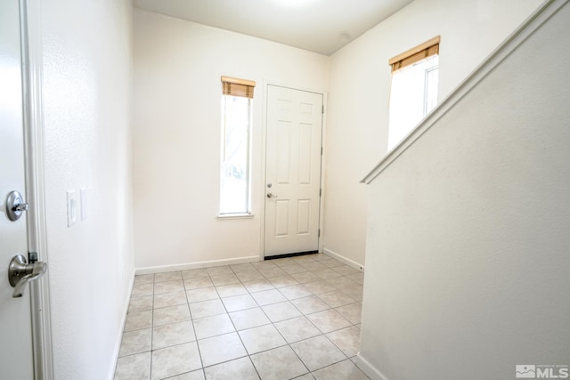 foyer featuring baseboards and light tile patterned floors