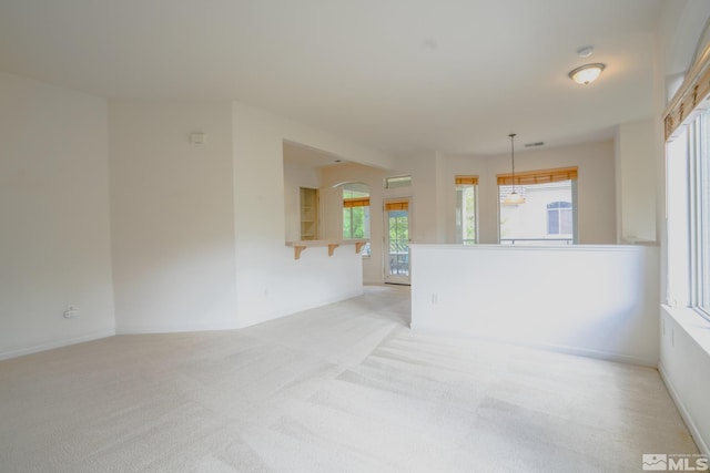 spare room with baseboards, visible vents, and light carpet